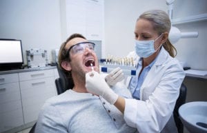 Female-dentist-examining-patient