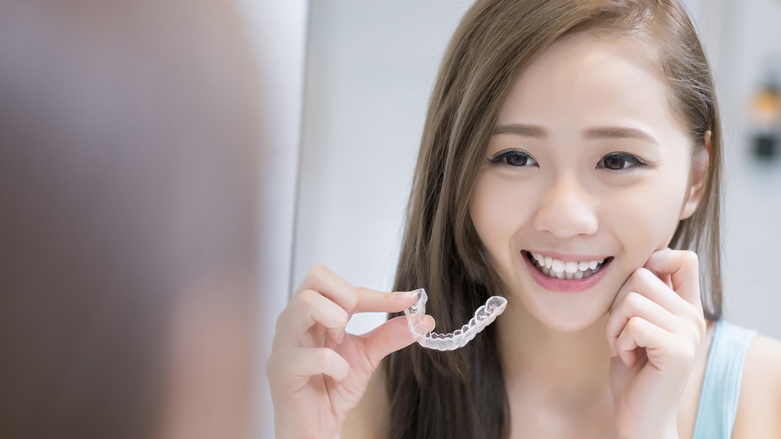 Smiling woman with aligners