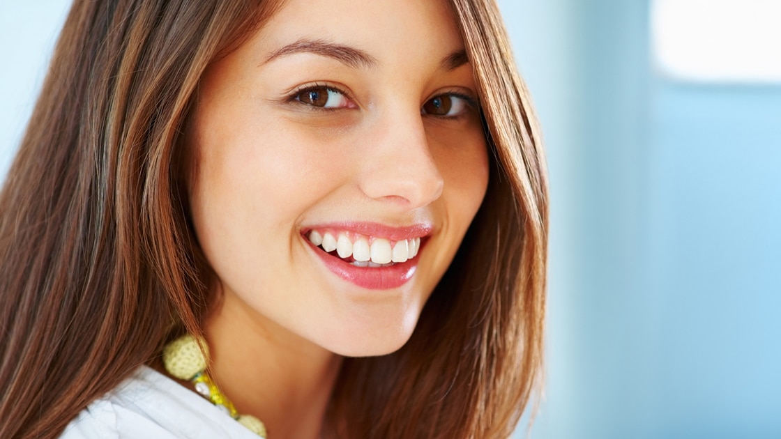 Woman in dental chair with tooth shade guide